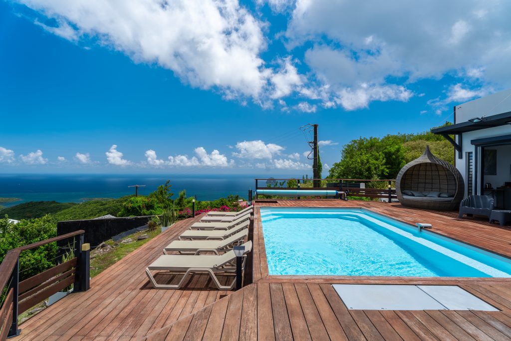Deck avec piscine et transat avec vue sur la mer